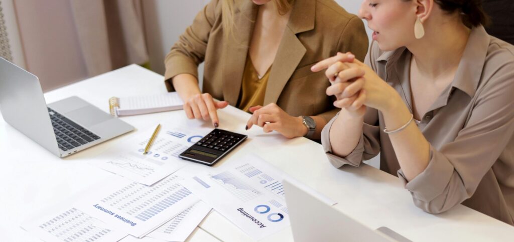 Two professionals collaborating on financial documents in a modern office setting.