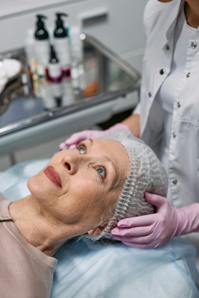 A senior woman undergoes a facial procedure at a medical clinic for rejuvenation.